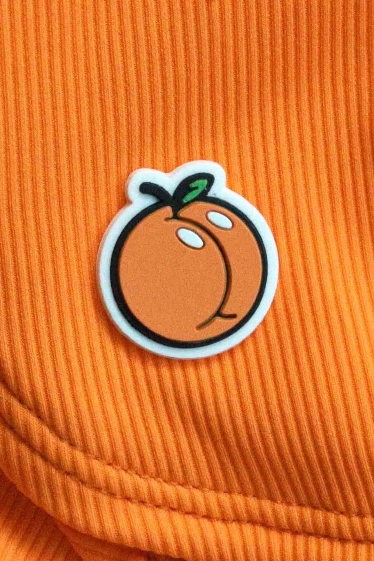 Citra fruit logo patch detail on the orange Clementine Cutie scoop top